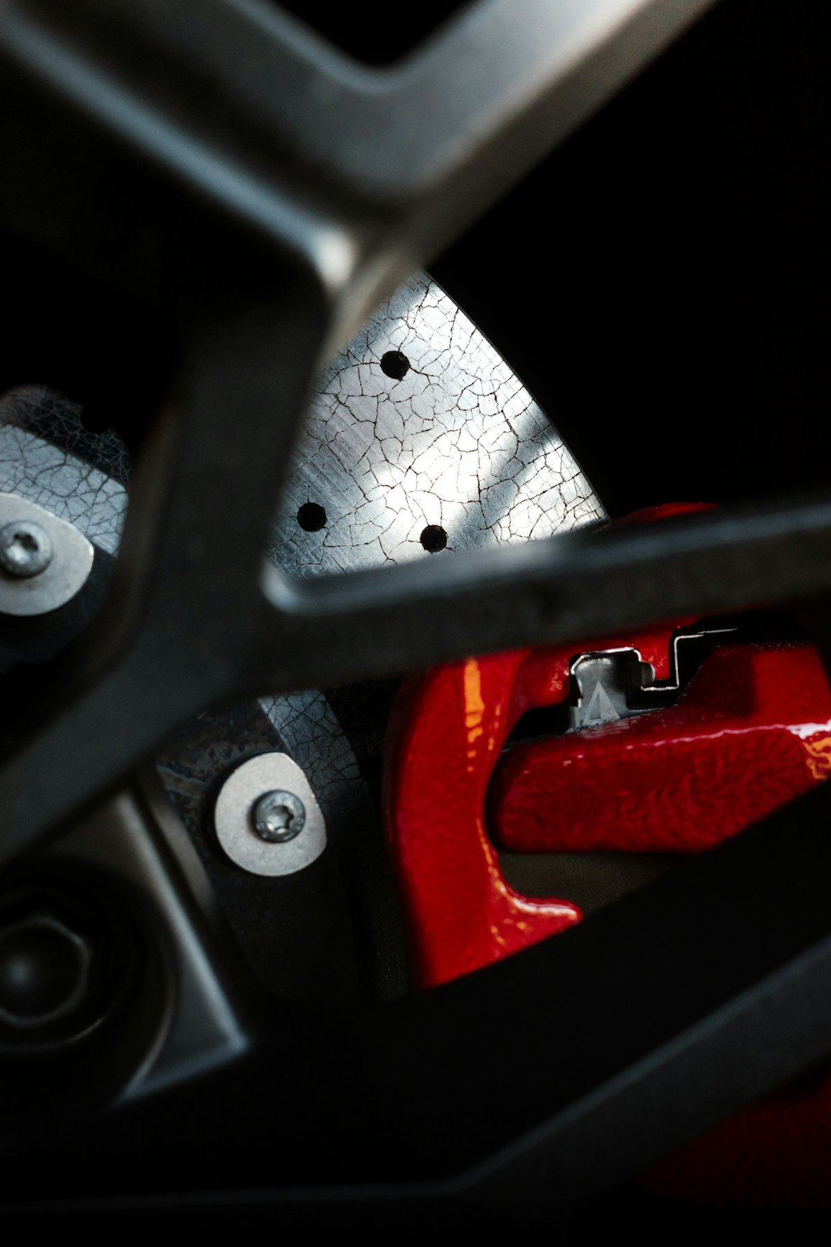 A red performance brake caliper behind a wheel